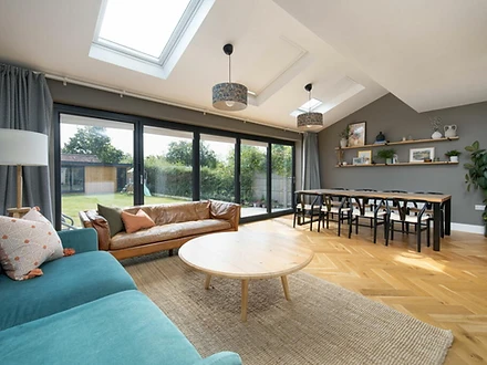 Open-plan dining and living area with folding glass doors