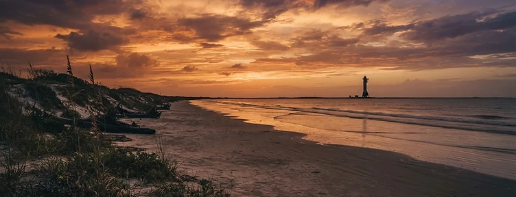 Boca Chica beach at sunset, South Texas Gulf Coast, distant launch tower on the horizon