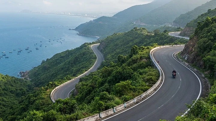 Hai Van Pass mountain road winding along the coastal cliffs above Da Nang Bay with the ocean visible below