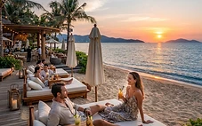 A stylish beach club in Da Nang with comfortable daybeds, umbrellas, and a view of the ocean at sunset.