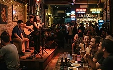 A cozy, dimly lit live music bar in Da Nang with a band performing on stage.