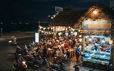 Late night food by area in Da Nang with illuminated seafood restaurants along the beachfront strip at night