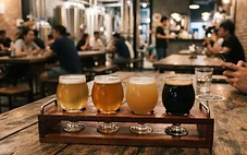 A flight of craft beers served on a wooden board at a modern Da Nang brewery.