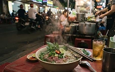 A steaming bowl of Vietnamese pho served at a late-night street food stall in Da Nang.
