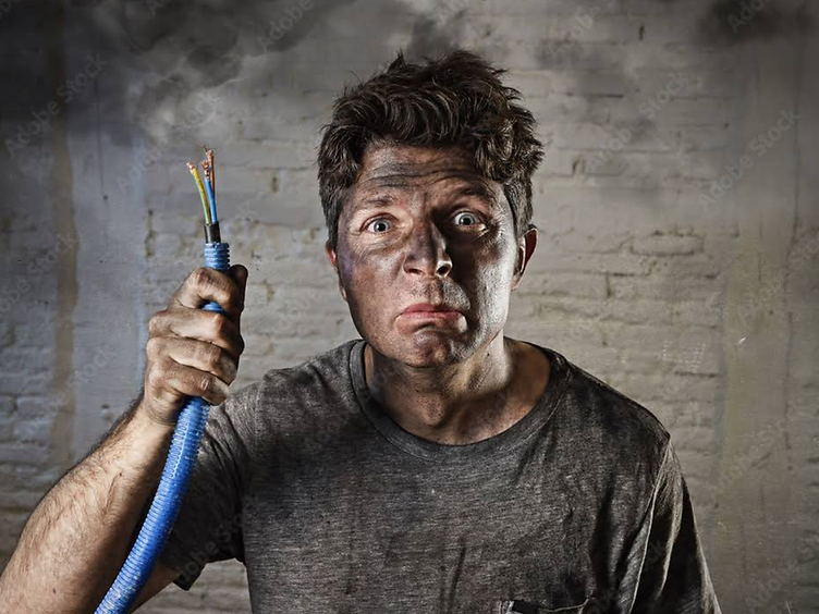 Man holding a burnt cable after a DIY electrical mishap