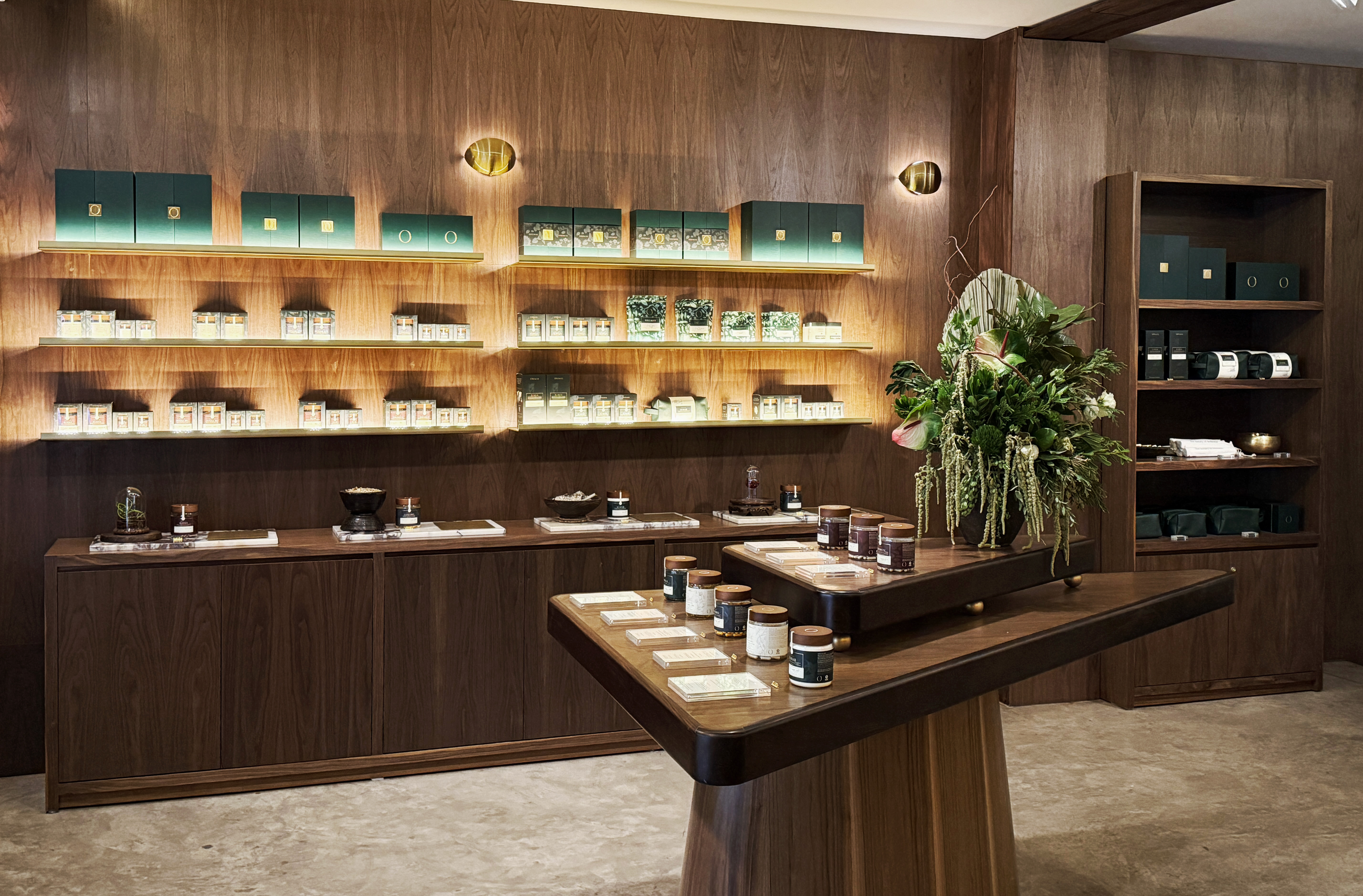 OXOMIO boutique interior with illuminated walnut shelving and product displays