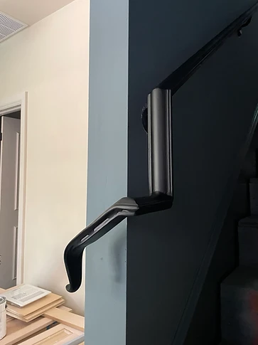 Angled view of the lower handrail return showing the vertical pickets and floor-mounted bases