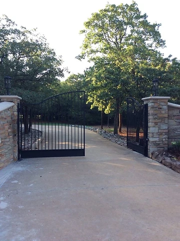 Minimal double-leaf metal gate between stone columns
