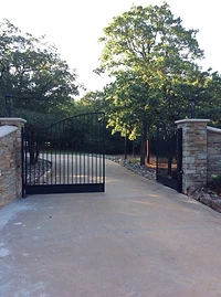 Minimal double-leaf metal gate between stone columns