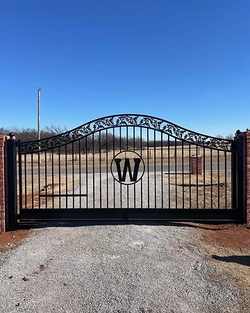 Ornamental estate driveway gate with custom monogram detail