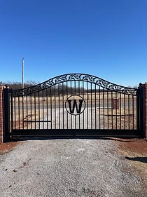 Ornamental estate driveway gate with custom monogram detail