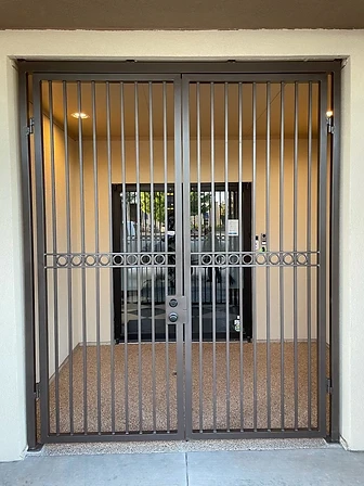 Double-leaf entry gate with circular decorative band spanning both leaves