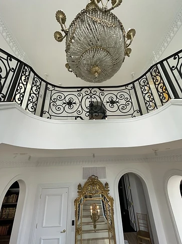 Ornamental iron railing continuing along the upper balcony level above the staircase