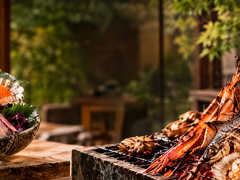 Fresh sashimi and robata-grilled seafood over glowing charcoal