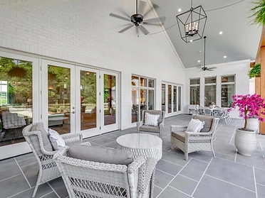 Patio lounge area with wicker seating and ceiling fan