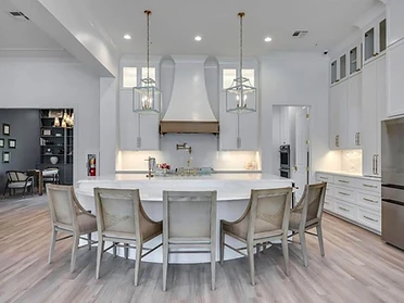 Open kitchen with white island and brass pendants