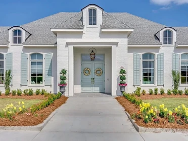 Symmetrical front entrance of The Oaks with arched windows and shutters