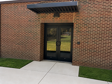Ackerman Elementary Addition double entry doors with black awning and brick facade