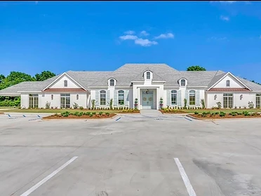 The Oaks front exterior facade with light-blue double doors