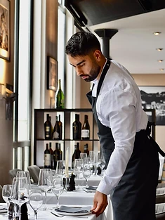 Kellner deckt den Tisch im Restaurant Laurent