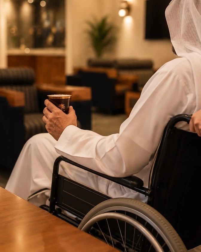 A guest in traditional Emirati dress being served Arabic coffee in the Siji Lounge