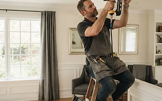 Contractor performing professional Residential Carpentry on crown molding in a bright home in Deal, NJ.