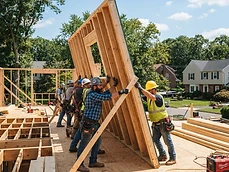 Construction crew standing on a platform raising a large wooden wall frame during residential framing in Avon-by-the-Sea, NJ.