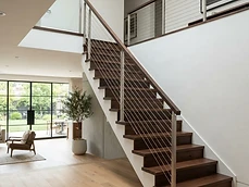 Custom Stairs and Railings with wooden treads and cable wire infill installed inside a Belmar, NJ home.