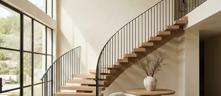 Curved floating wooden stairs and minimalist black metal railing installed at a residence in Rumson, NJ.