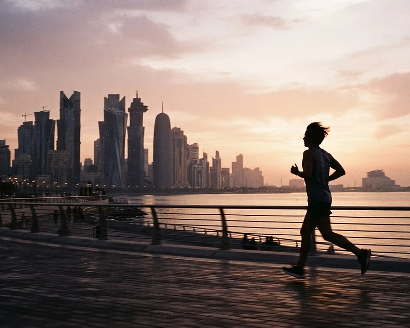 Runner at sunrise over West Bay, Doha