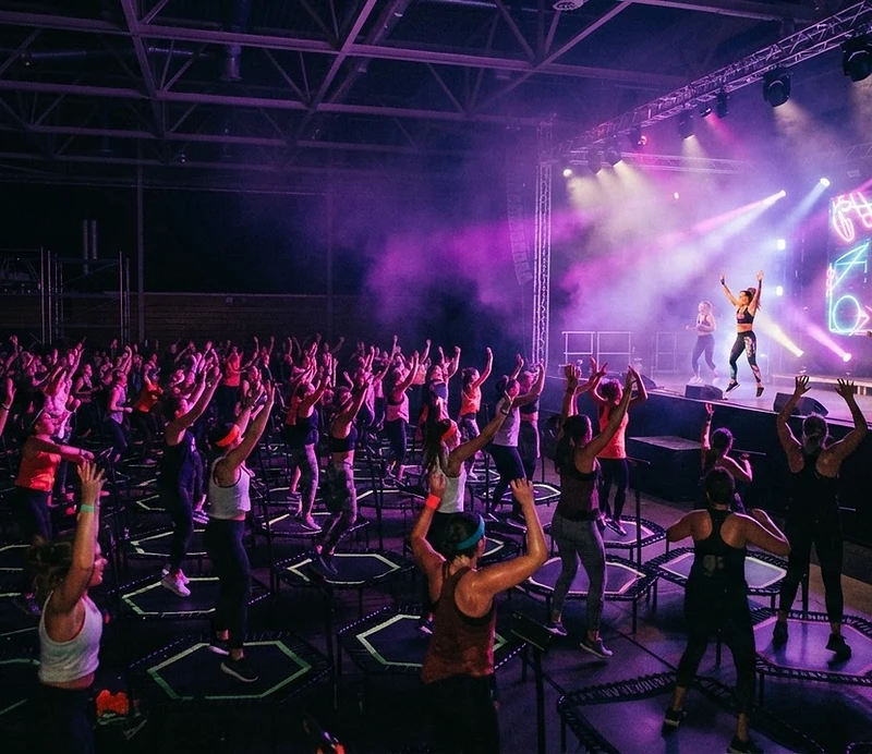 JUMPUP FITNESS PARTY — tłum skaczący na trampolinach w świetle sceny