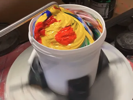 Screen printing ink being mixed on a mixing machine with swirling primary colors