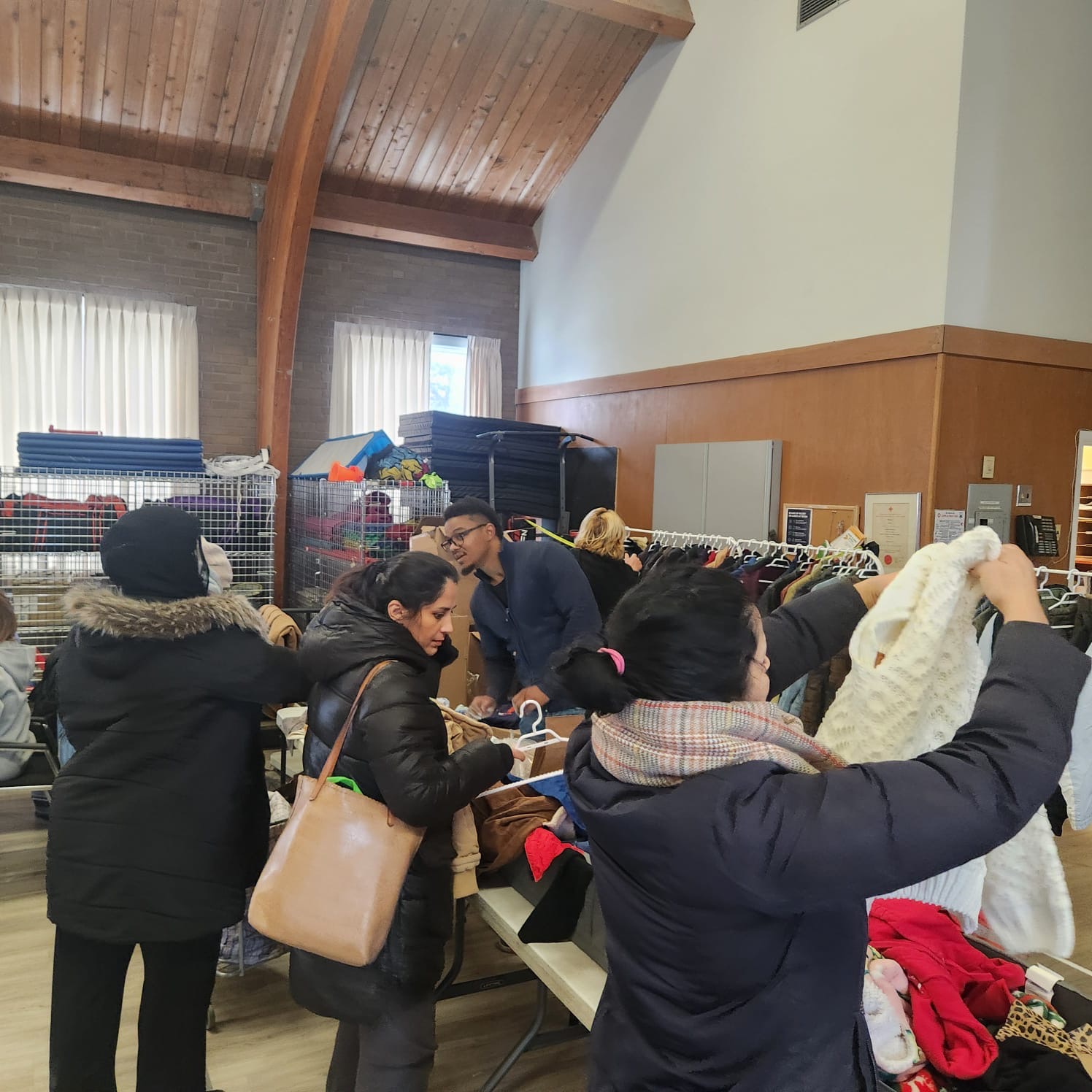 Folding tables covered in sorted clothing and socks at a community hall distribution