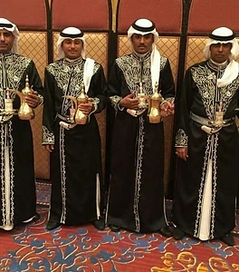 فريق قهوجيين بزي رسمي أبيض بدلال ذهبية وفضية جاهزون لخدمة المناسبات