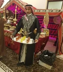 قهوجي تراثي يحمل صينية شاي في مناسبة سعودية أصيلة