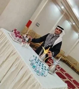 قهوجي سعودي بزي تراثي يقدم الضيافة في مناسبة رسمية