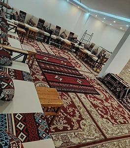 مجلس عربي تراثي فاخر مزيّن بالسجاد الأحمر والوسائد المطرّزة لاستقبال المناسبات