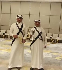 فريق قهوجيين بزي أسود مطرّز يحملون دلال ذهبية في حفل أفراح