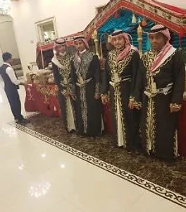 فريق قهوجيين بزي تراثي مع دلال بجانب مجلس عربي مزيّن