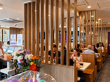 Inside Sushi Hanamaru — warm wooden booths and our purple Hanamaru sign
