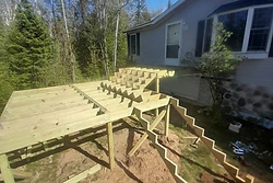 Wooden deck framing and stairs under construction by All Aspects