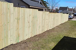 Newly installed pressure-treated wood privacy fence built by All Aspects in Sault Ste. Marie, Michigan