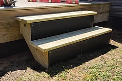 Newly built deck steps with black risers by All Aspects
