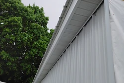New white soffit and corrugated metal siding installed on a building corner by All Aspects