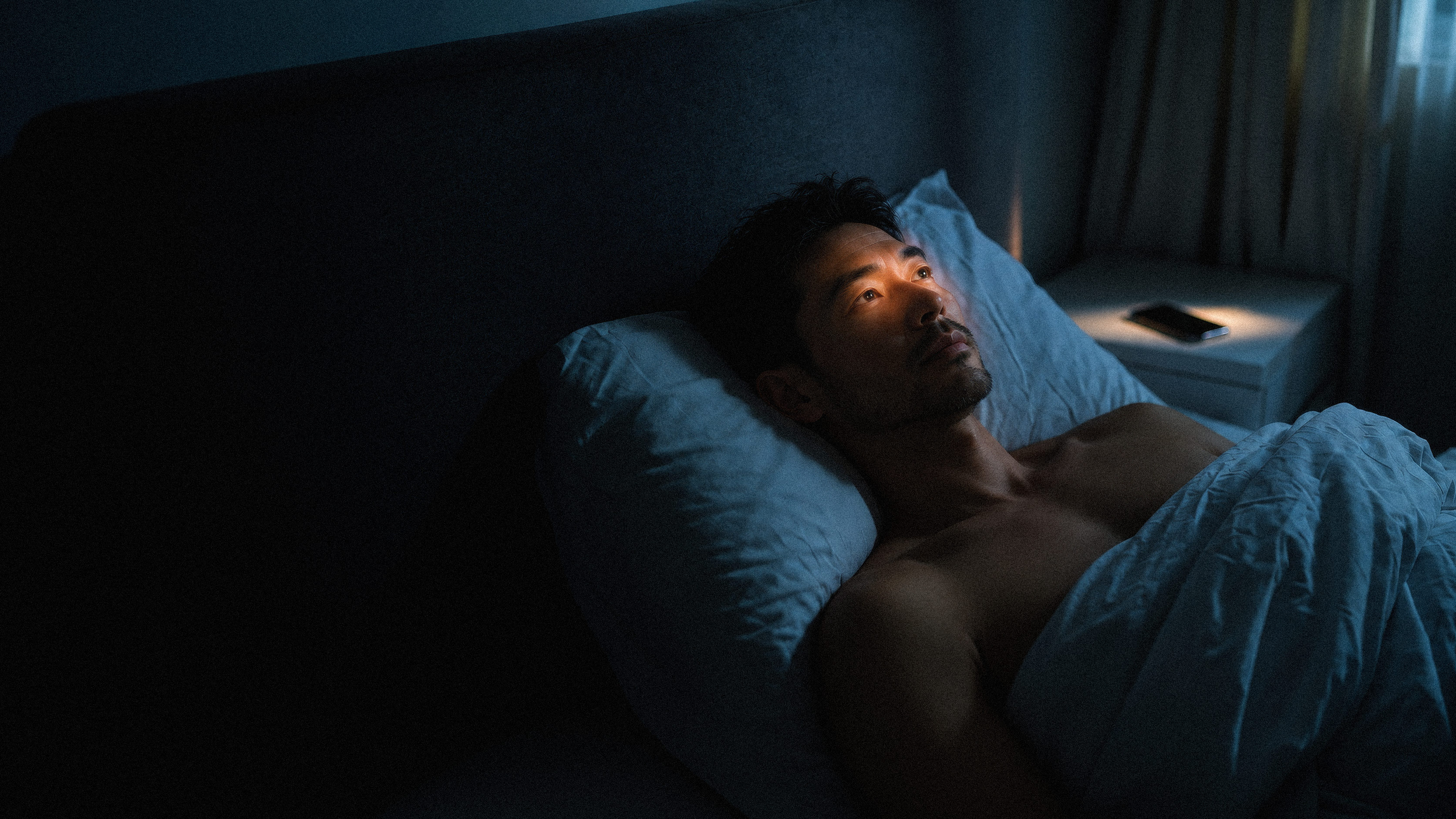 A person lying awake in bed at night