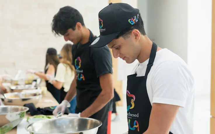A volunteer slicing cucumbers in the Beit Hachesed Kitchen