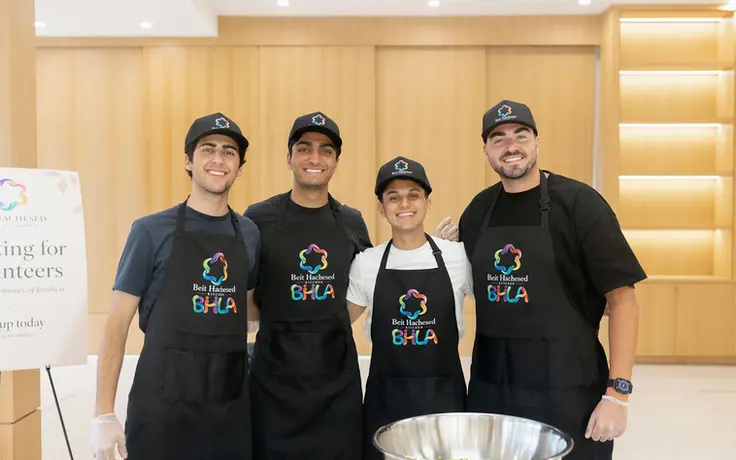 Four Beit Hachesed Kitchen volunteers smiling together