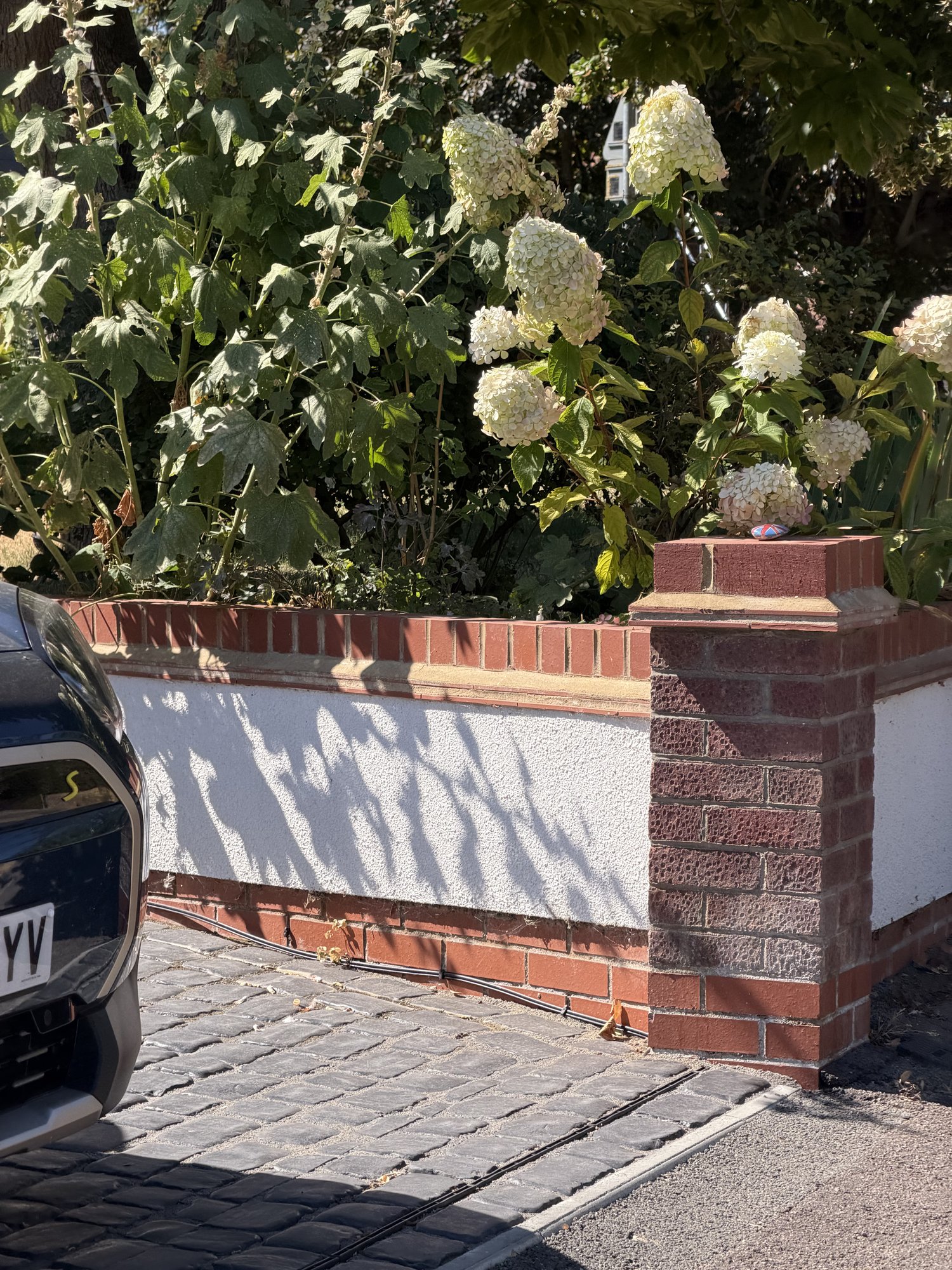 Rendered wall with brick capping