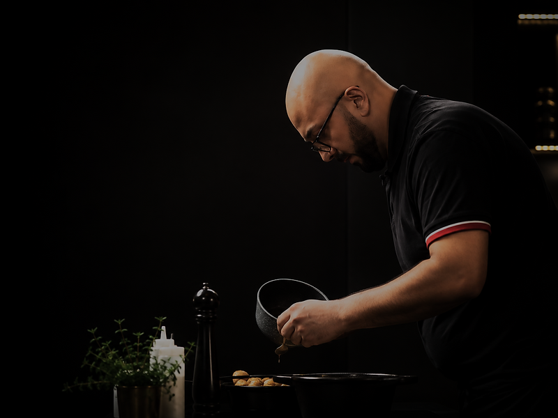 Plating a dish in a dark kitchen