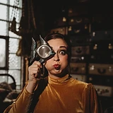 Woman making a fish face with a fish-shaped magnifying glass